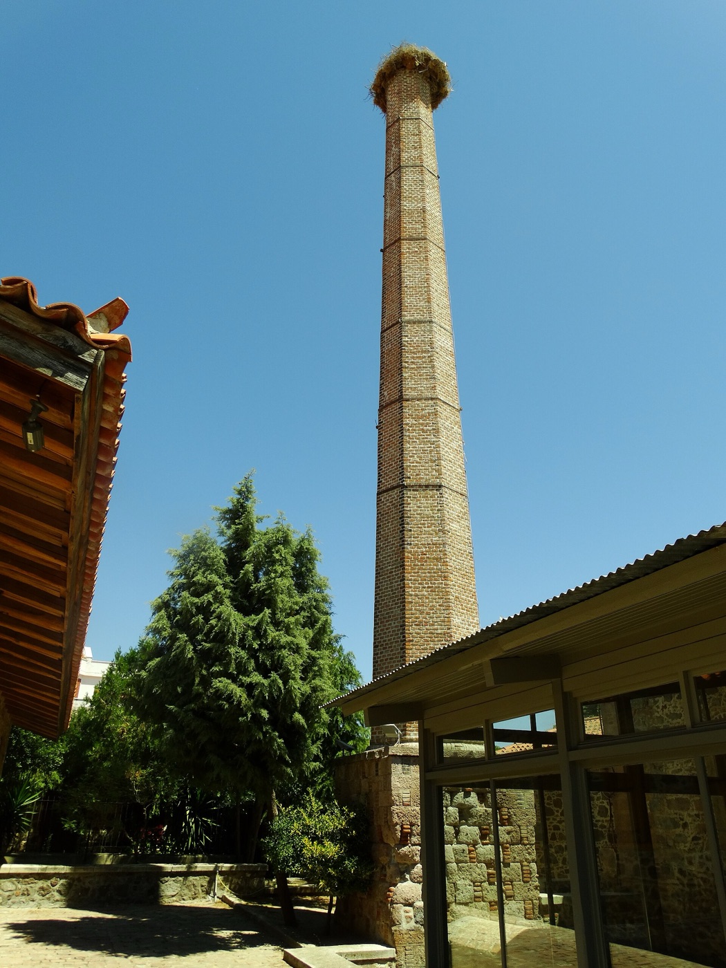 Ayia Paraskevi'deki ortak yağhanenin bacası. Yapı bugün Midilli Endüstriyel Zeytinyağı Üretimi Müzesi olarak kullanılıyor. Fotoğraf: PanosMtln (CC BY-SA 4.0).